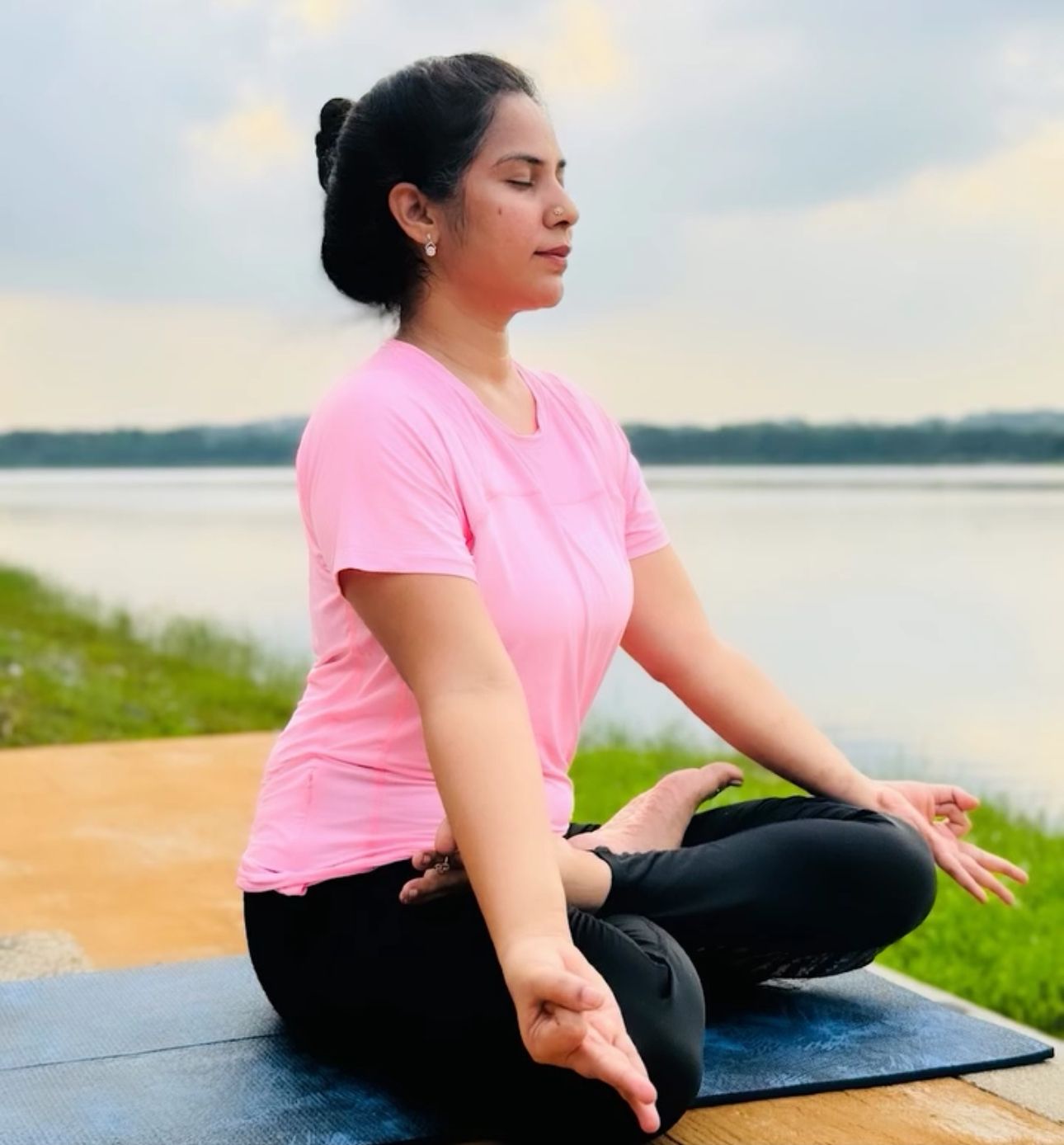 Yamini Parsa Avatapalli seated in meditation by the water